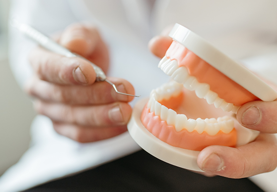 Man in blue shirt sitting in dental chair and smiling