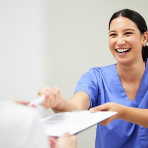 Patient in La Crosse filling out paperwork for dental emergencies