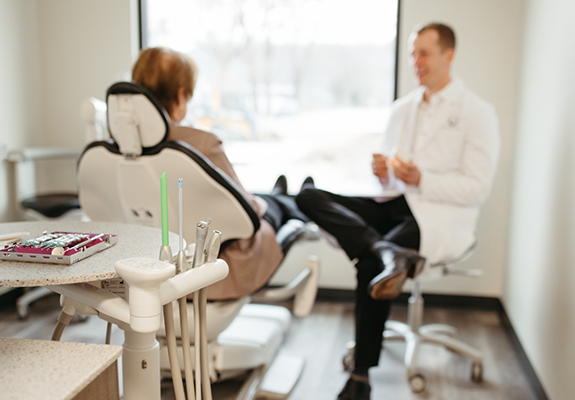 Woman in the dental chair talking to Doctor Saphner