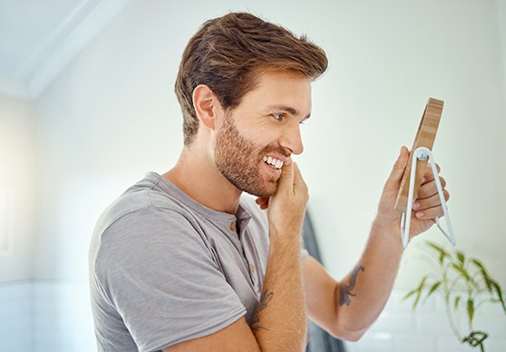 Patient looking in the mirror after professional teeth whitening