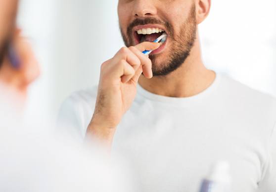Patient in La Crosse smiling while holding a cup of coffee after teeth whitening