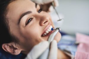 Woman smiling during teeth cleaning.
