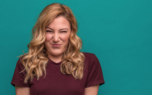 Woman in dark purple shirt with bitter taste in mouth 