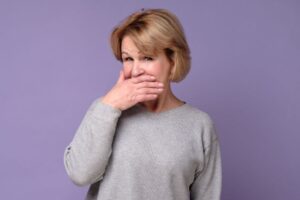 Concerned mature woman covering her mouth 