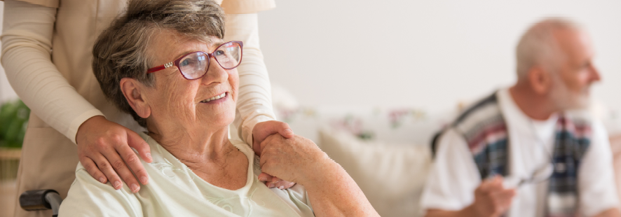 Elderly woman holding hands with carer